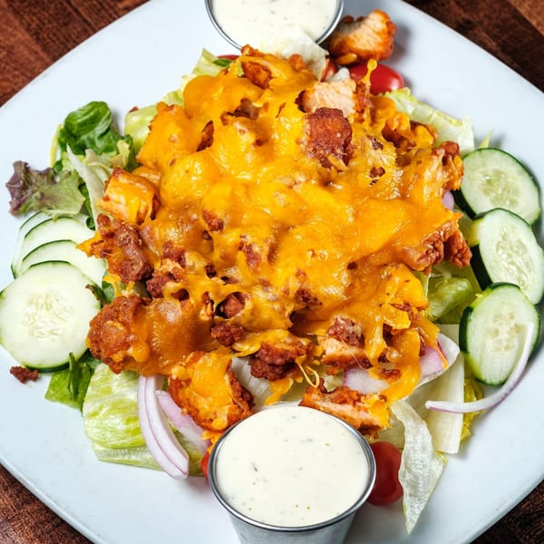 Gotham City Diner's crispy chicken salad with melted cheddar, lettuce, cucumbers, red onions, and cherry tomatoes.