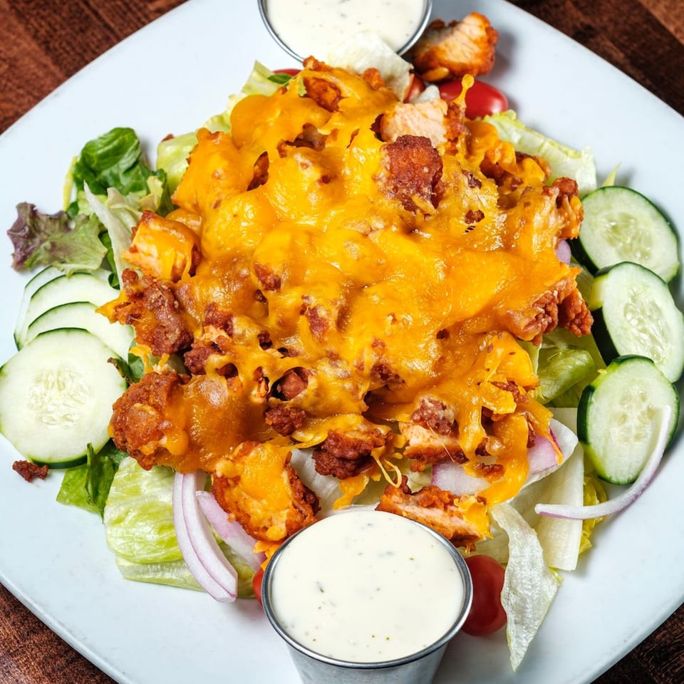 Gotham City Diner's crispy chicken salad with melted cheddar, lettuce, cucumbers, red onions, and cherry tomatoes.