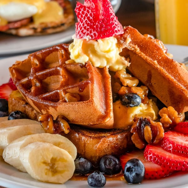 Gotham City Diner's waffle and French toast combo with fruit, nuts, and whipped cream.