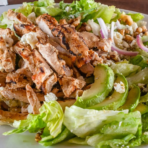 Grilled chicken salad with avocado, red onion, walnuts, and feta cheese from Gotham City Diner.